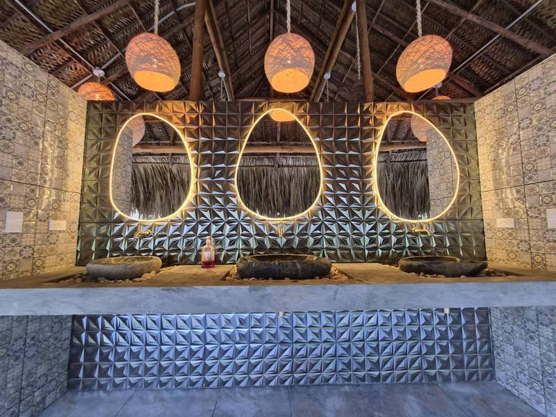 Baños compartidos bajo techo de palma