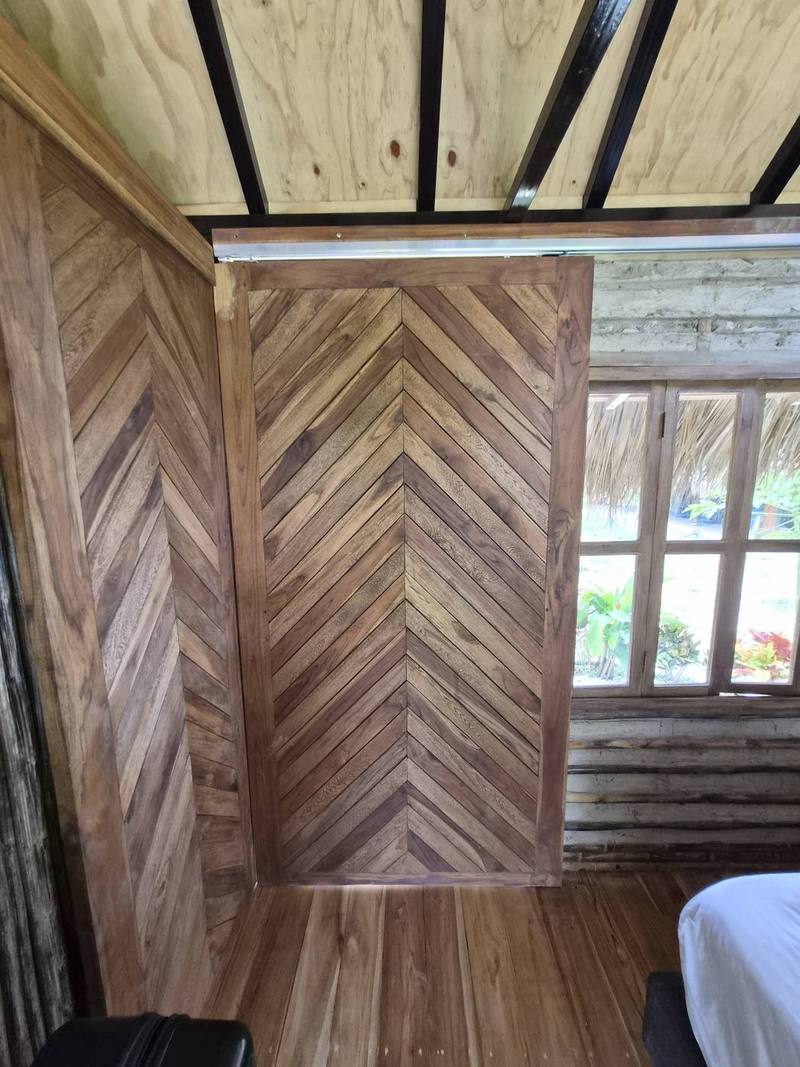 Puerta de madera en espina de pescado de la cabaña Tierra Magia
