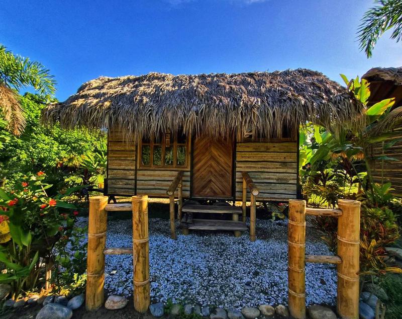 Cabañas y kiosco de palma entre el jardín